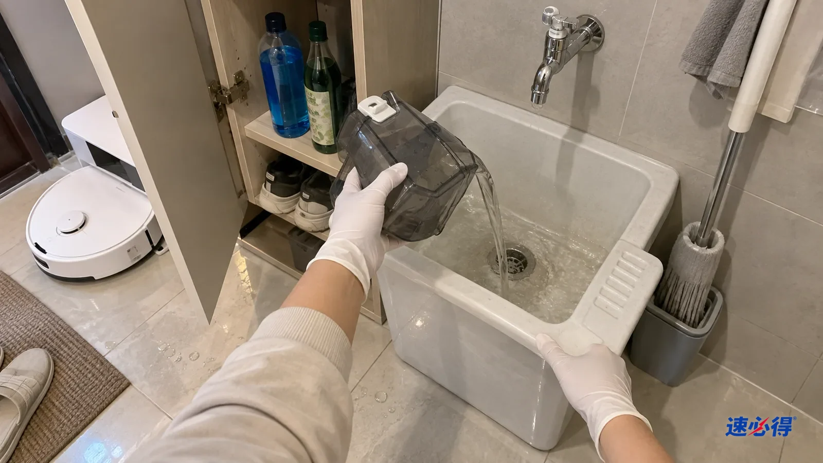 戴手套的手把扫地机器人清水箱里的液体倒进拖把池，旁边柜里立着玻璃水和花露水瓶。