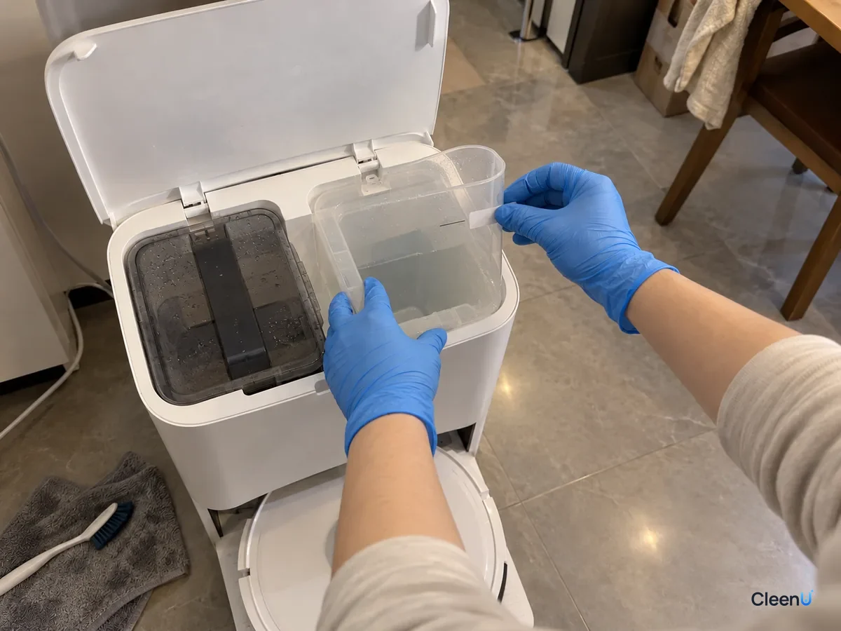 Blue-gloved hands mark the liquid level on the open dock's clear compartment after filling it with measured solution.