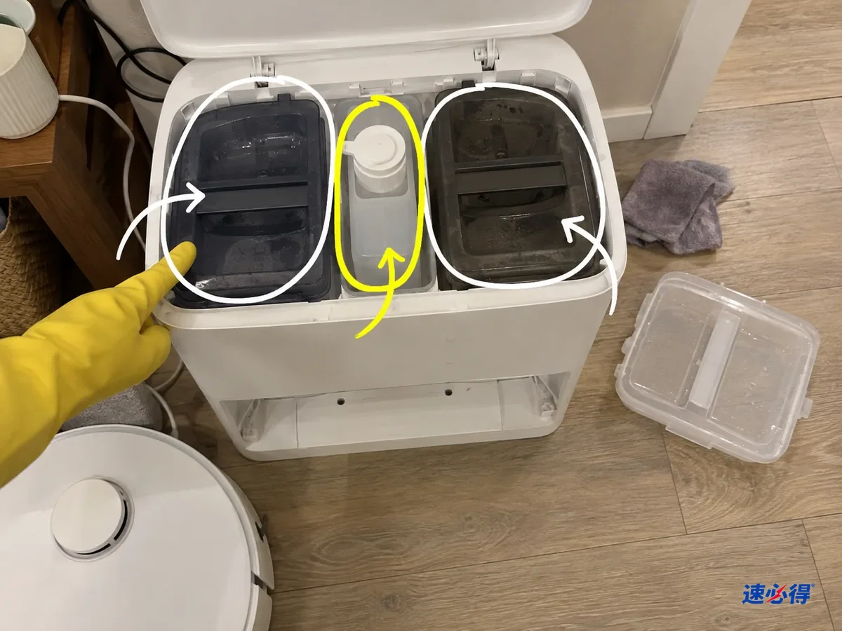 掀开上盖的白色基站里，清水箱、污水箱和中间的清洁液瓶位被分别标出