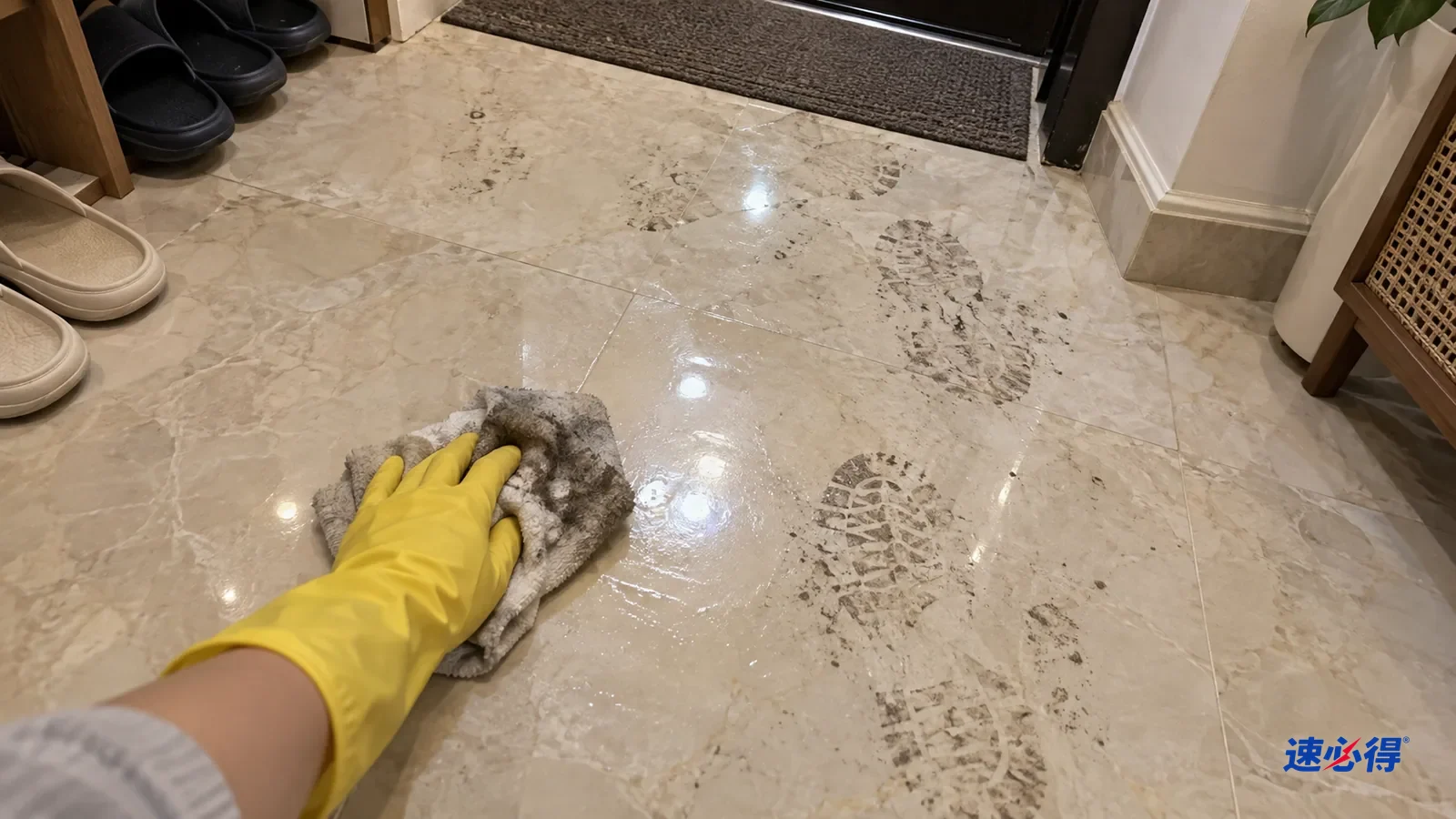 第一视角，戴黄色橡胶手套的手用拧干软布擦门厅大理石地面上的脚印灰痕，布面沾灰，擦过的一块反光均匀，旁边仍有灰脚印，拖鞋在一边。