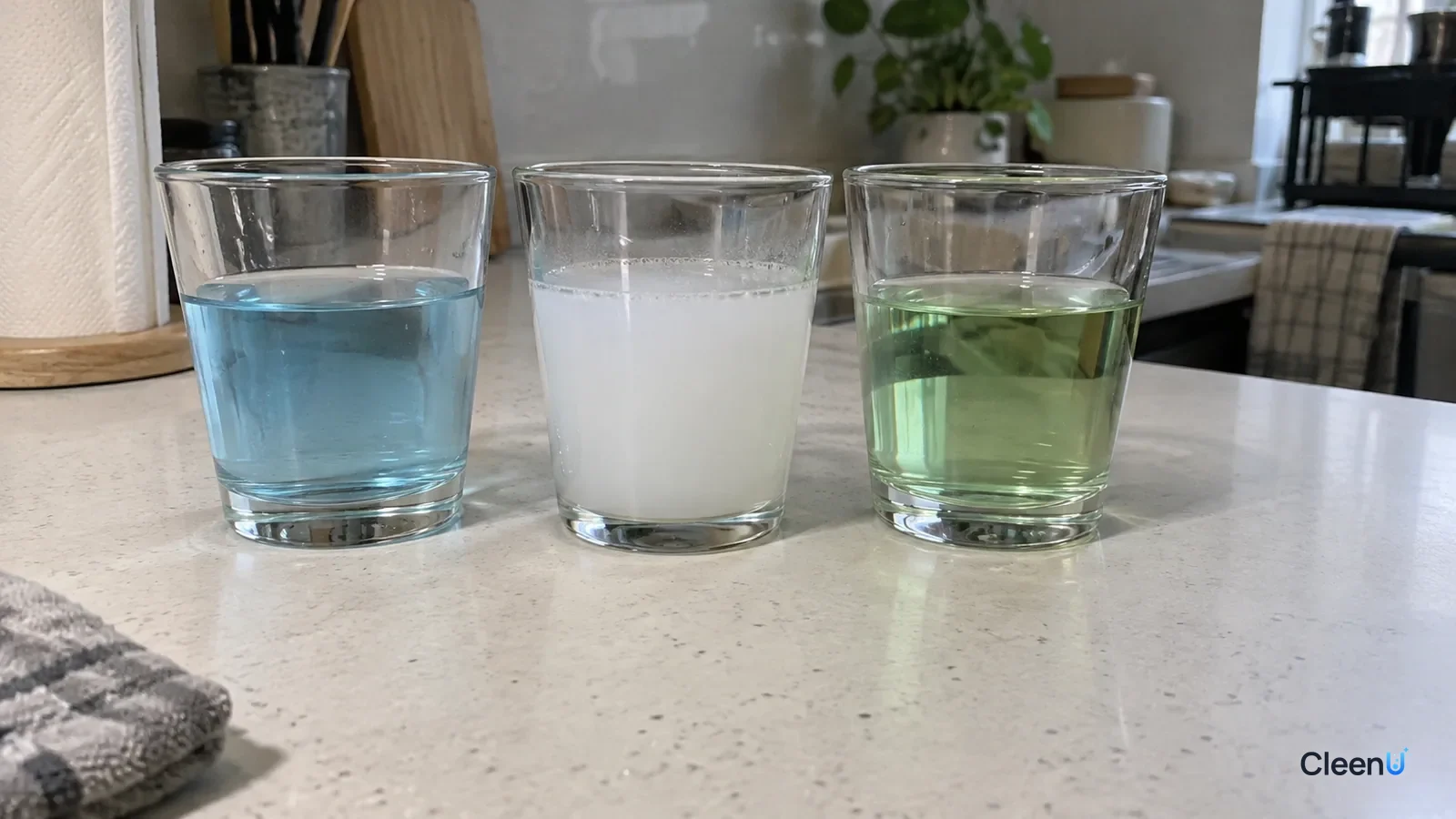 AI illustration: Measuring cups of blue and green liquids beside a cup of cloudy liquid