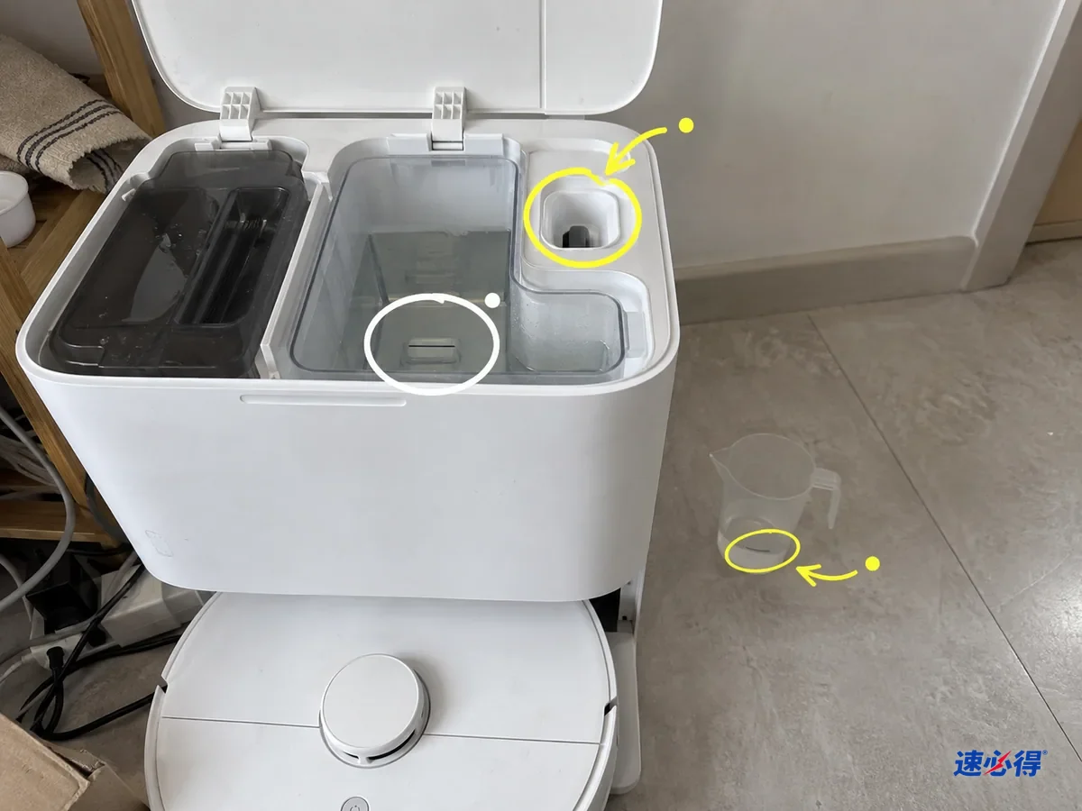 打开的基站水箱仓里，加液口、水位处和旁边量杯底部的刻度位置被标出