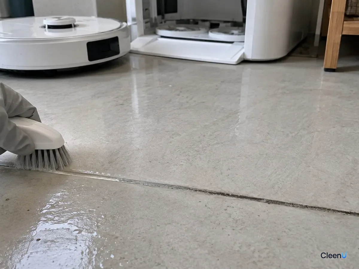 AI illustration: Close-up of a grout line where a section brushed with a soft brush has returned to light gray while the unbrushed part next to it is still dark
