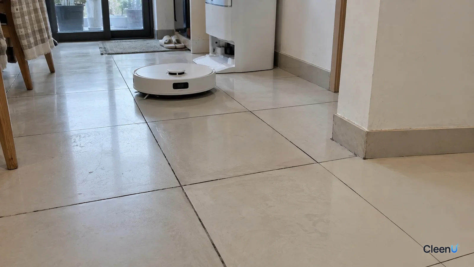 AI illustration: Light tile flooring where grout lines along the robot mop's usual path are clearly darker than the grout in the corners