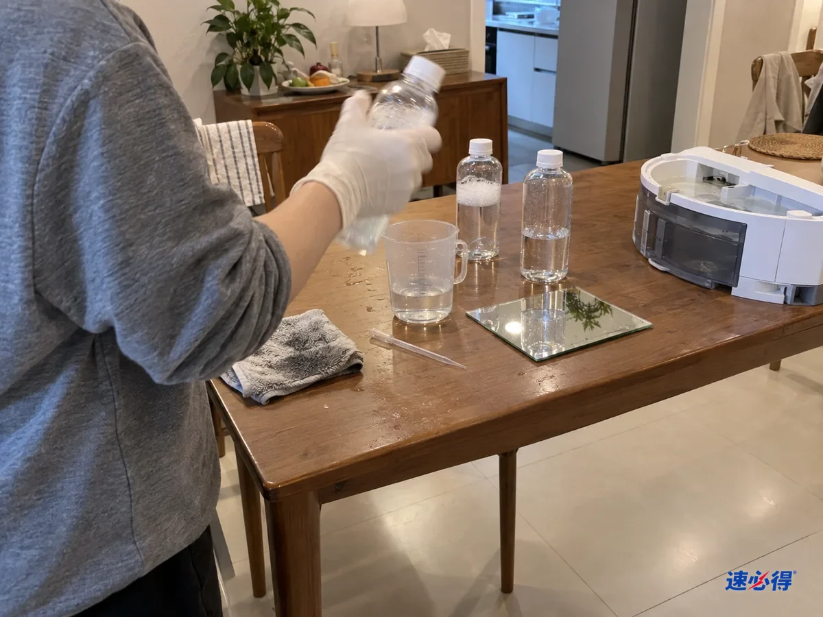 一人在餐桌旁摇晃装稀释液的小瓶测试泡沫，桌上还有量杯、镜面试片和扫地机器人水箱。