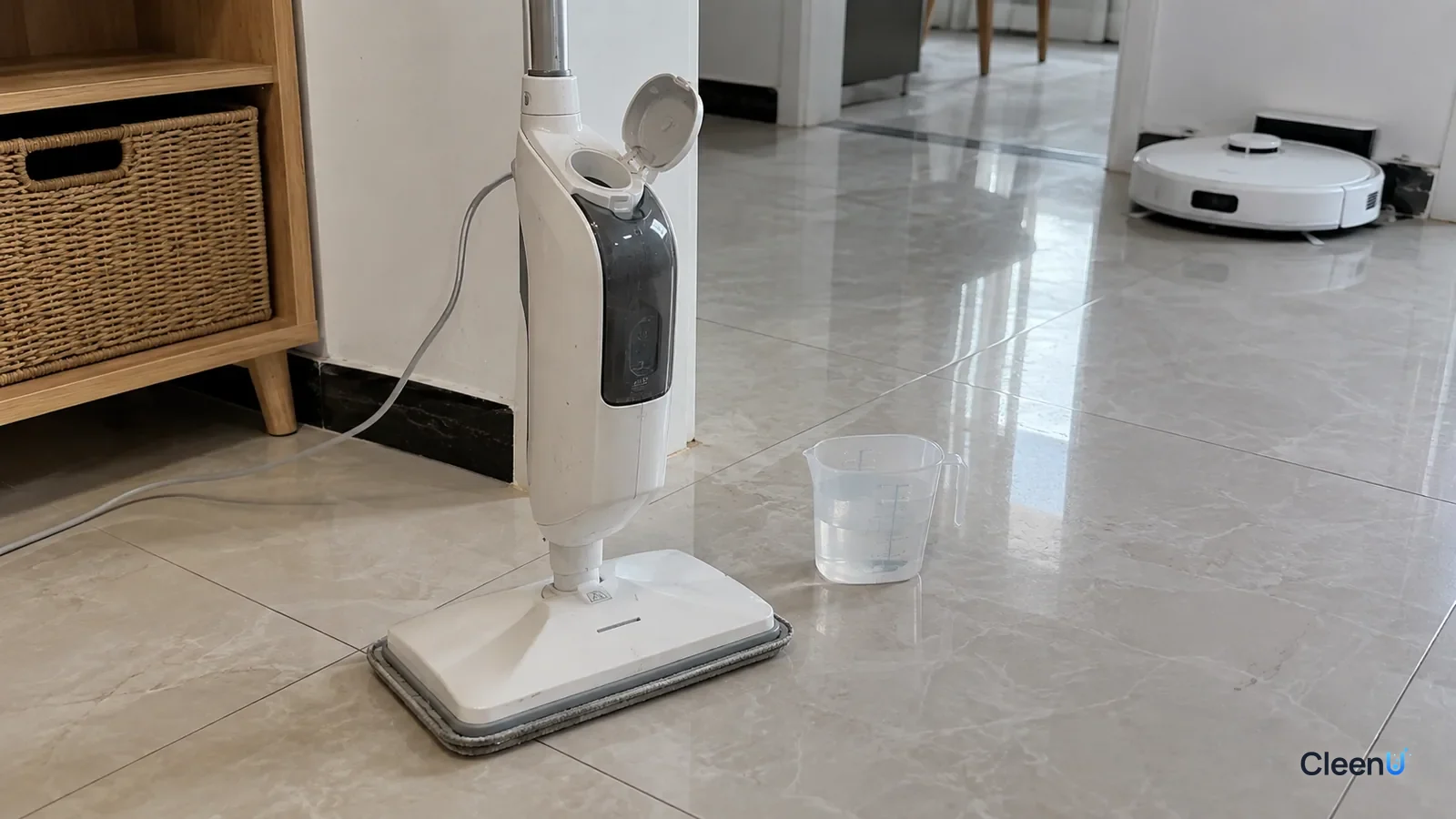 AI illustration: A white steam mop standing on a tile floor with its tank cap open, a measuring cup of plain water on the floor beside it and a white robot mop parked in the background